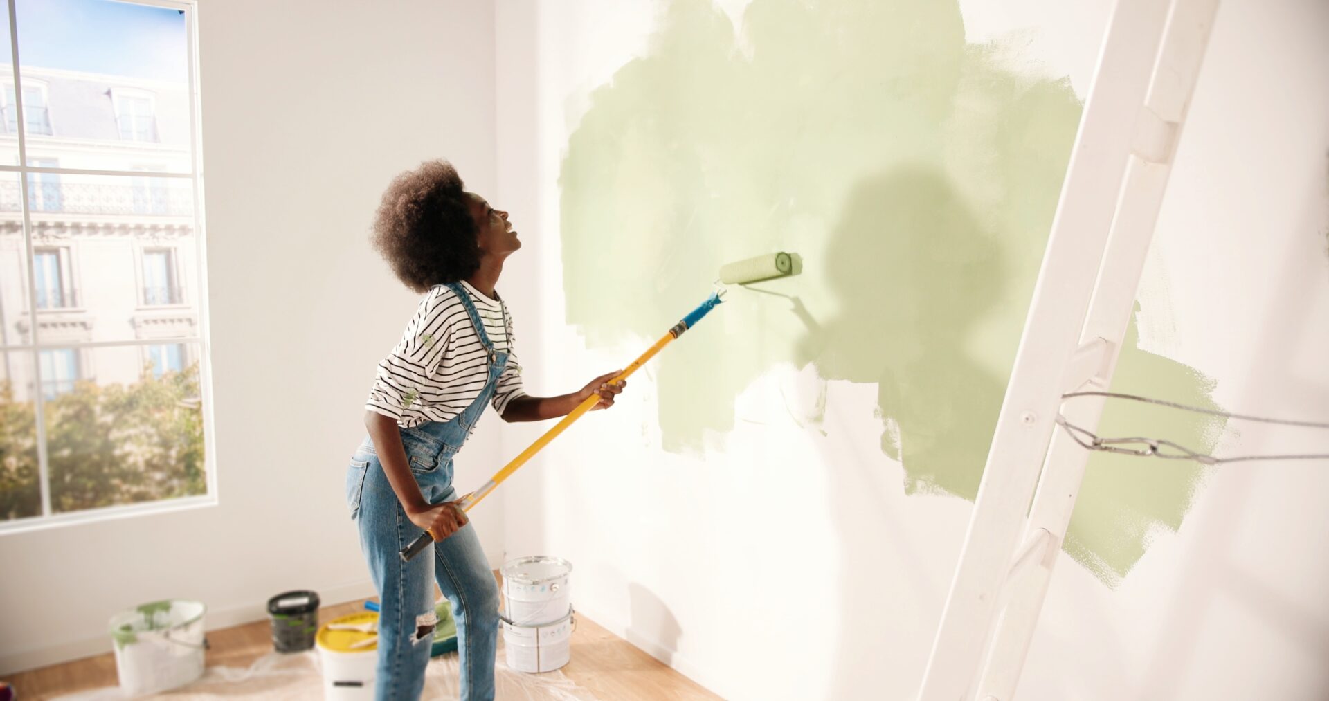 Femme qui peint le mur d'une nouvelle maison